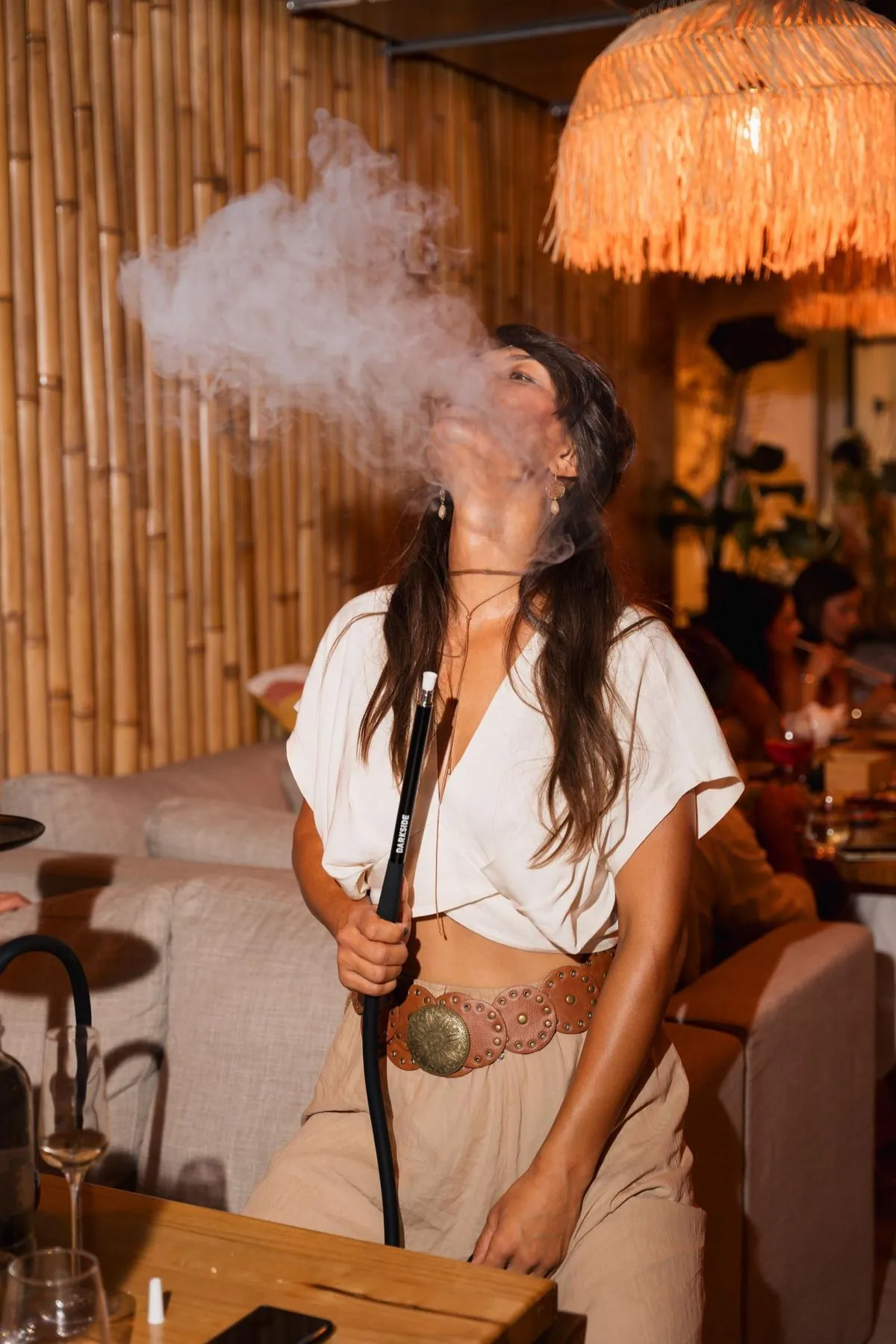 Oaspete care savureaza shisha la o masa Komodo Lounge