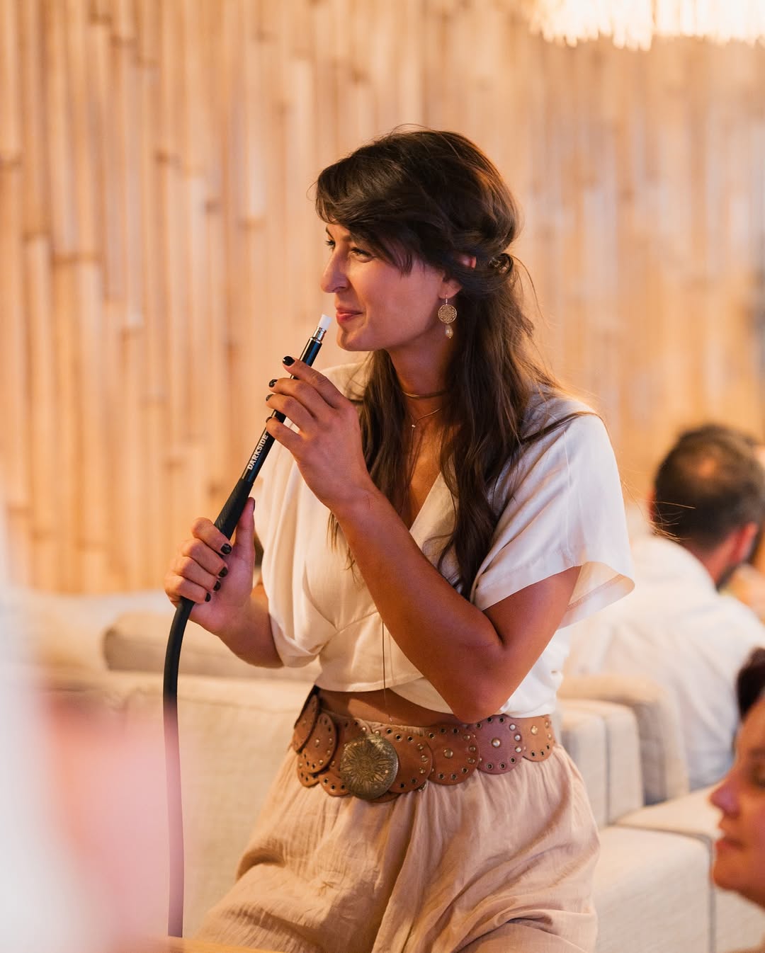 Guest with a shisha pipe at the bamboo wall