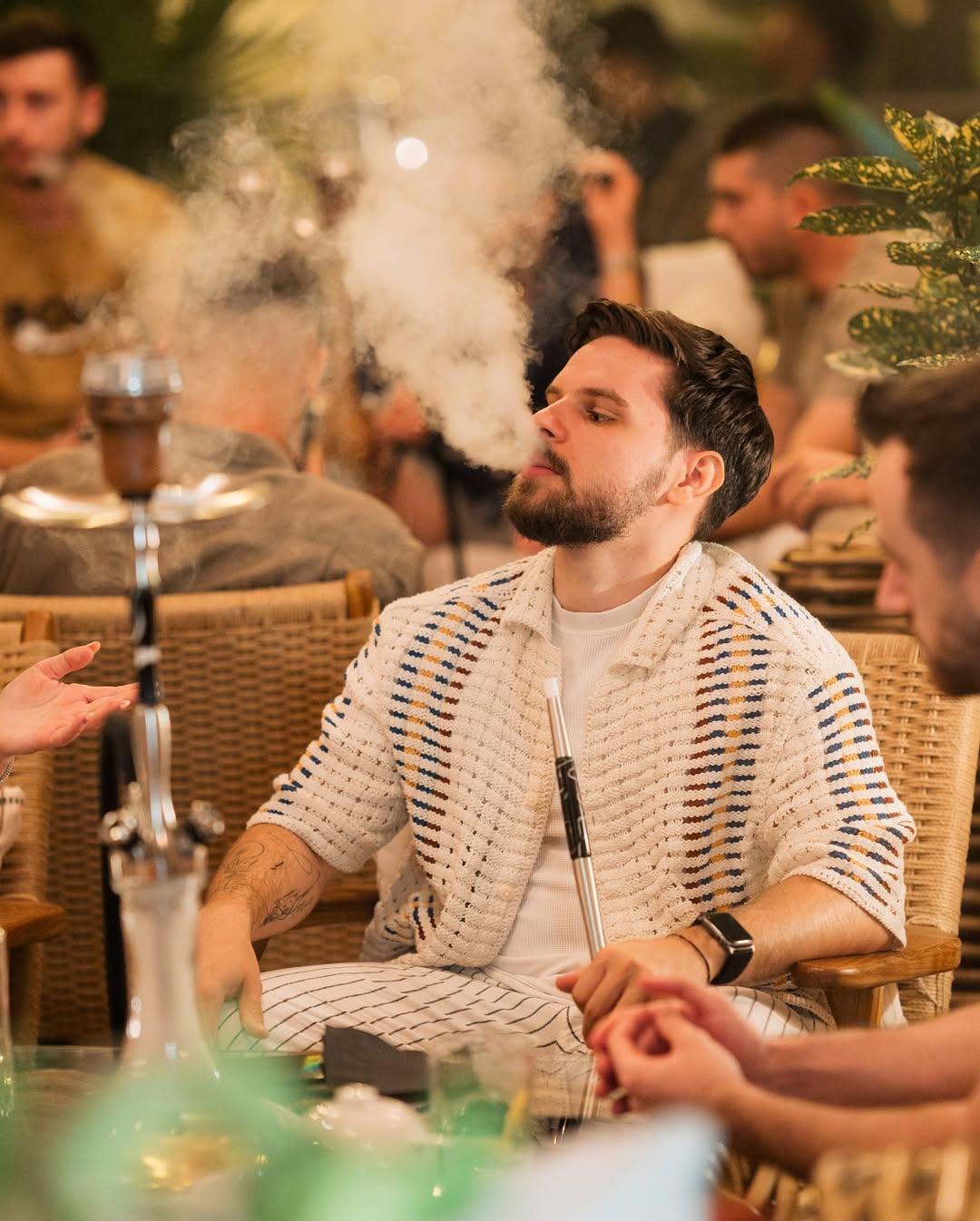 Guest exhaling shisha smoke in the lounge